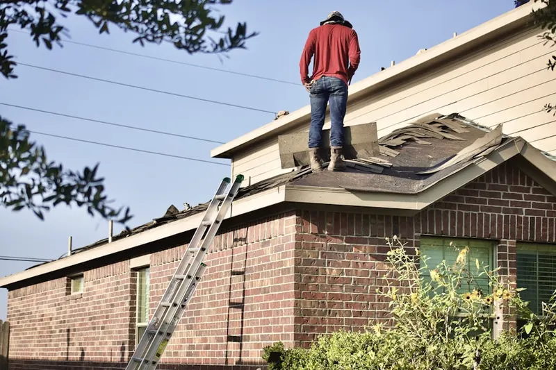 Professional roofer working on a residential roof in Fort Myer